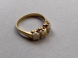 a gold ring with pearls on it on a table