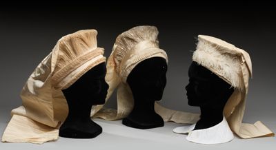 trois têtes de mannequin sont alignées les unes à côté des autres sur une surface grise