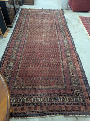 un tapis posé au sol au milieu d'une pièce où se trouve un canapé rouge