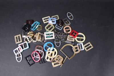 a lot of different colored metal buckles on a table