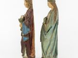 two wooden statues of jesus and mary, one holding a child