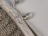 a silver chainmail purse with a flower on it
