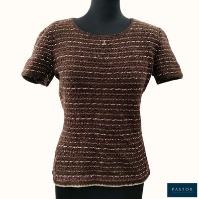 Le haut du t-shirt de cette femme est marron et doré.