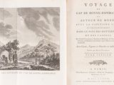 an old book with a picture of a mountain in the background