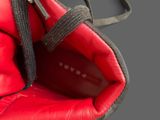 a close up of a red boxing glove with a black strap