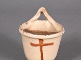 a small bowl with a cross on it on a gray surface