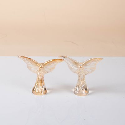 pair of gold angel figurines on a white surface
