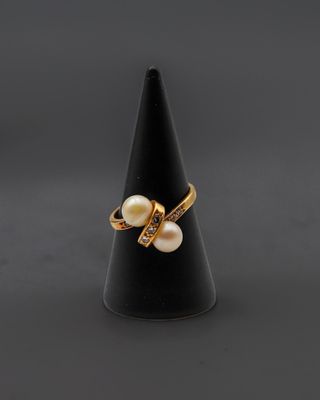 une bague en or sertie de perles et de diamants, montée sur un cône noir