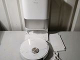 a white robot sitting on a table next to a white wall