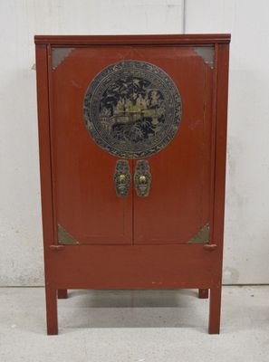 une petite armoire rouge ornée d'un décor doré