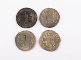 four different types of coins sitting on top of a white surface