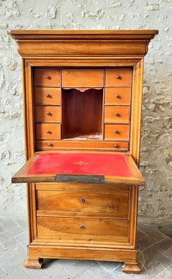 an old wooden desk with a red top and drawers
