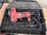 a tool box with a corded drill and other tools on a table