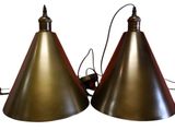 pair of brass lamps with red lampshads on a white background