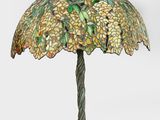 une lampe de table surmontée d'un abat-jour en verre