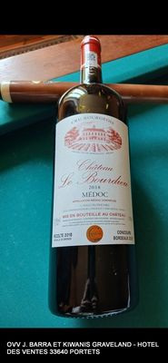 une bouteille de vin posée sur une table de billard, à côté d'une queue de billard
