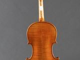 an old violin on a stand against a gray background