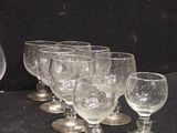 several empty wine glasses are lined up on a black table