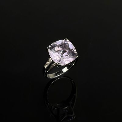 une bague en améthorate et diamant posée sur une surface noire