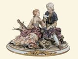 a figurine of a man and a woman sitting on a rock