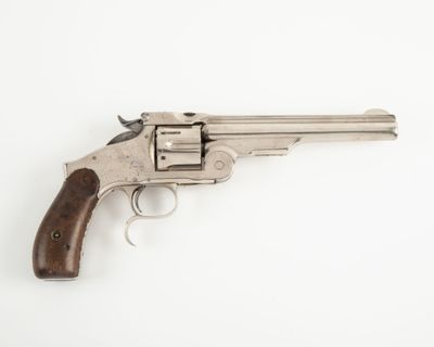 un revolver en argent avec une poignée en bois sur une surface blanche