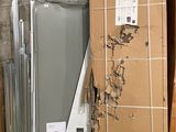une pile de cartons et un réfrigérateur dans un coin de la pièce