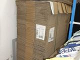 a large stack of boxes in a room with a ladder