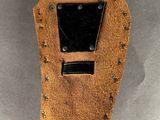 a close up of a brown leather case with a black button on it