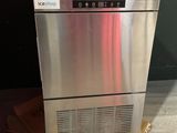 an image of a stainless steel ice maker sitting on top of a cardboard box