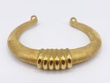 a close up of a gold cuff with three beads on it