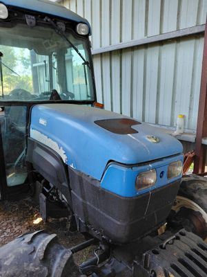 un tracteur bleu garé devant un bâtiment