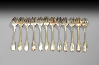 six fourchettes sont disposées en rangée sur une surface blanche