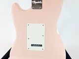 a pink electric guitar sitting on top of a tripod stand