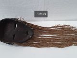 a brown mask with long hair sitting on top of a white table