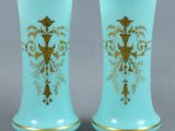 une paire de vases bleus ornés de motifs dorés, posés sur une table