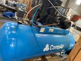 a blue air compressor sitting on a pallet in a warehouse