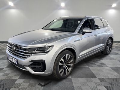 une Volkswagen Touareg argentée garée dans une grande pièce