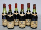 six bottles of wine are lined up on a marble surface