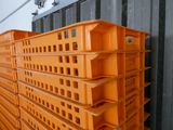 plusieurs caisses en plastique orange empilées les unes sur les autres dans un entrepôt