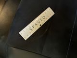 a black bag with a label on it sitting on a black chair