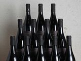 Des bouteilles de vin sont posées sur une table en bois devant un mur
