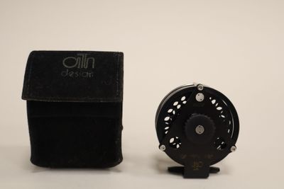 a small black box with a black fly reel next to it