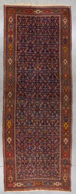 un tapis persan ancien présentant un motif géométrique sur fond bleu