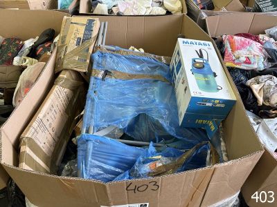 de nombreuses boîtes contenant des vêtements et d'autres objets, empilées les unes sur les autres