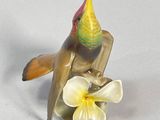 a figurine of a bird sitting on a flower