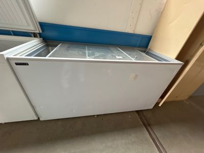 un congélateur coffre blanc installé dans une pièce