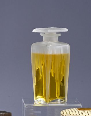 a bottle of liquid sitting on top of a table next to a basket