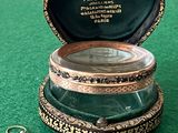 a small box with a ring inside of it on a green surface