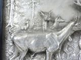 a metal plaque with a deer, deer, and other animals on it