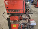 a red machine sitting on top of a cart in a warehouse